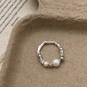 Macro view of handmade silver ring with irregular texture and white pearl details