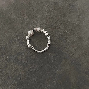 Handmade elastic silver ring featuring round pearls and irregular metallic texture