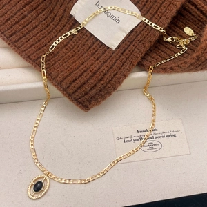 Élégant collier Figaro doré avec un pendentif ovale en pierre noire au style raffiné