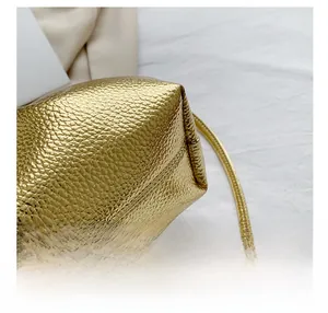Detail of golden cloud bag showing premium lychee grain leather and neat stitching