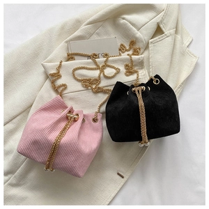 Detailansicht von Kord-Beuteltaschen mit Goldketten und weißen Perlen-Kordelzügen