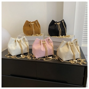 Detailansicht fünf farbiger Cord-Beuteltaschen mit Goldketten und Perlenverzierungen
