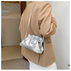 Detail of silver metallic bucket bag showing lychee grain texture and drawstring design