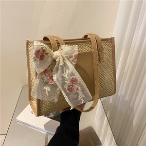 Elegant straw tote bag with brown leather trim and floral embroidery ribbon detail