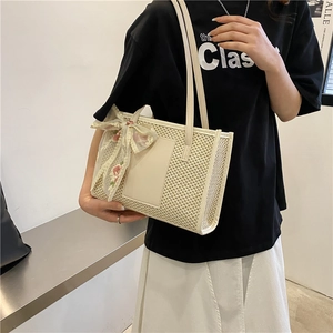 Elegant woven straw tote bag in beige with floral silk scarf detail for summer beach use