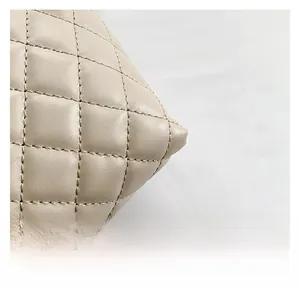 Macro shot of fine diamond quilting craftsmanship and stitching on beige tote bag