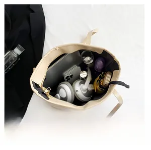 Spacious interior of beige tote bag showing capacity for tablet, headphones, and bottle