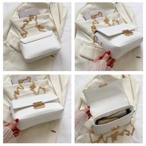 Detail view of white chain bag featuring a gold clasp and internal storage capacity
