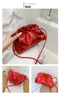 Detail of red metallic pleated cloud bag with magnetic closure and slim shoulder strap