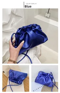 Detail of royal blue metallic gathered pouch bag with slim crossbody strap and soft texture