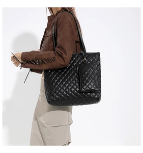 Detail of black quilted tote bag showing texture and matching detachable small zipper pouch