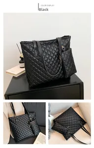 Detail of black quilted tote bag with matching mini pouch and gold hardware accents