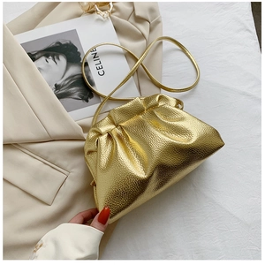 Detailed view of the metallic gold pleated bucket bag with a slim shoulder strap