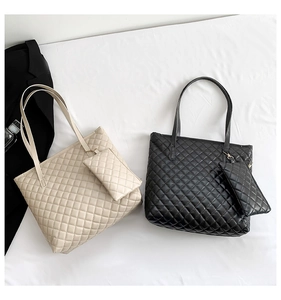 Detail view of large quilted tote bags in beige and black with matching inner pouches