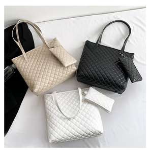 Flat lay of quilted tote bag set in beige black and white with matching pouches
