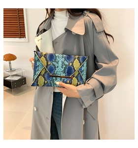 Detail of blue and yellow snakeskin envelope clutch with gold metal trim
