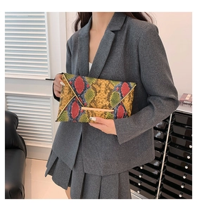 Detail of colorful snakeskin print envelope clutch with gold metal buckle closure