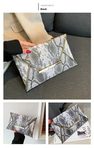 Macro detail of snake print envelope clutch bag with elegant gold V-shaped metal trim