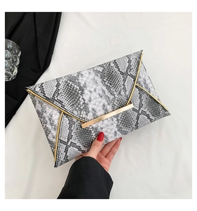 Close-up of snakeskin pattern clutch with gold metal trim and buckle hardware details
