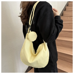 Detail of a bright yellow nylon crescent shoulder bag with matching round coin purse pouch