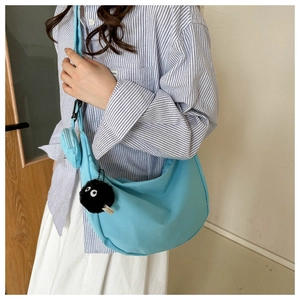 Light blue canvas crescent crossbody bag with mini pouch and plush charm detail