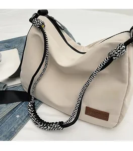 Detail of cream canvas tote bag with woven strap, leather tag, and casual lifestyle props