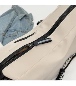 Close-up of smooth black zipper with reflective puller on white canvas tote bag