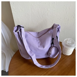 Detail of purple nylon dumpling bag showing textured fabric and round coin purse attachment