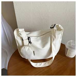 Detail of white canvas crossbody bag with a round coin purse and minimalist Korean style