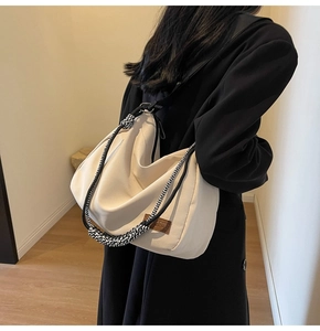 Detailed view of cream canvas hobo bag with thick black and white woven strap