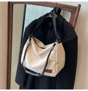 Detail of off-white large canvas tote featuring woven handles and leather JINGPIN logo