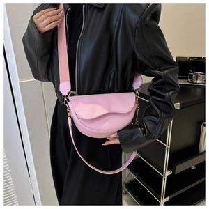 Détail de sac besace rose avec bandoulière tissée et chaîne métallique argentée