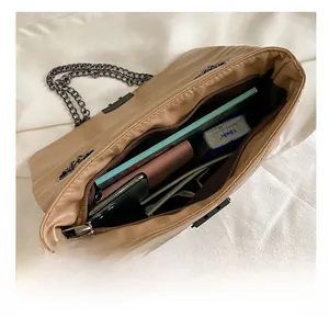 Interior view showing the large capacity of the brown quilted shoulder bag for daily items