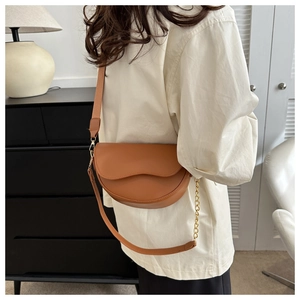 Sacoche marron en similicuir avec bandoulière large portée par un mannequin