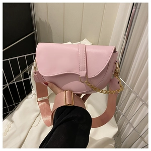 Sac selle rose avec large bandoulière en toile et élégante chaîne dorée en vue de style de vie