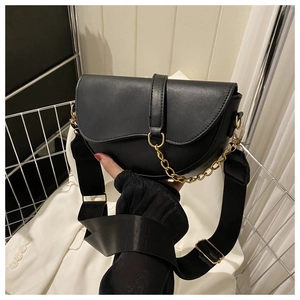 Vue détaillée du sac selle noir avec chaîne dorée et large bandoulière en nylon