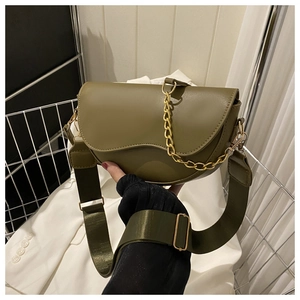Détail du sac selle en cuir vert armée avec bandoulière tissée et chaîne dorée