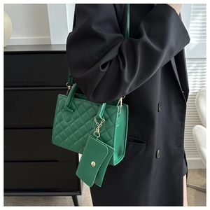 Close-up of green quilted leather crossbody bag with mini pouch and gold hardware