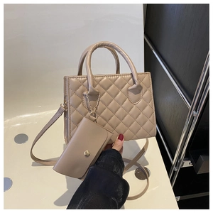 Détail du sac beige matelassé avec petit porte-monnaie et bandoulière à chaîne dorée