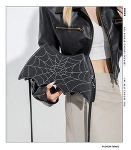 Close-up of gothic black bat handbag featuring spider web embroidery and heart detail