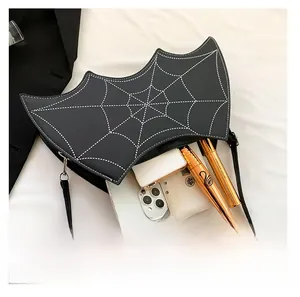 Interior capacity of bat-shaped spider web bag showing phone and cosmetics storage