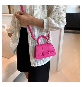 Hot pink trapezoid handbag with pebble texture shown worn as a crossbody bag
