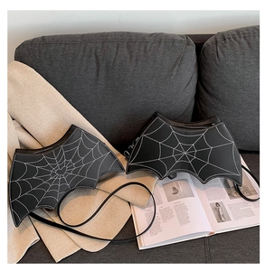 Detail of gothic bat wing crossbody bag with white spider web embroidery on faux leather