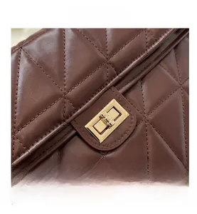 Macro shot of dark brown quilted leather bag with gold rectangular metal turn-lock