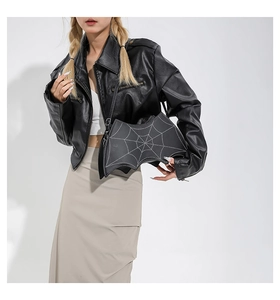 Detail of bat-shaped crossbody bag with spider web pattern on black PU leather