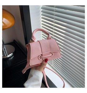 Detailed close-up of pink litchi grain leather and stitching on this mini handbag