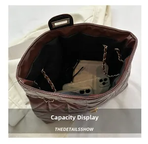 Brown quilted handbag showing large internal capacity for phone and long wallet