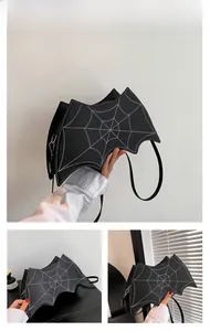 Detail showing the black bat-shaped crossbody bag with white spider web stitching