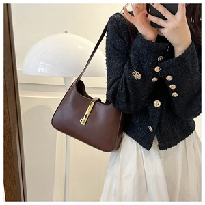 Detailed view of the dark brown leather hobo bag with a distinctive golden piston lock