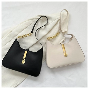 Detail view of stylish underarm bags with gold chain straps and metal lock closures